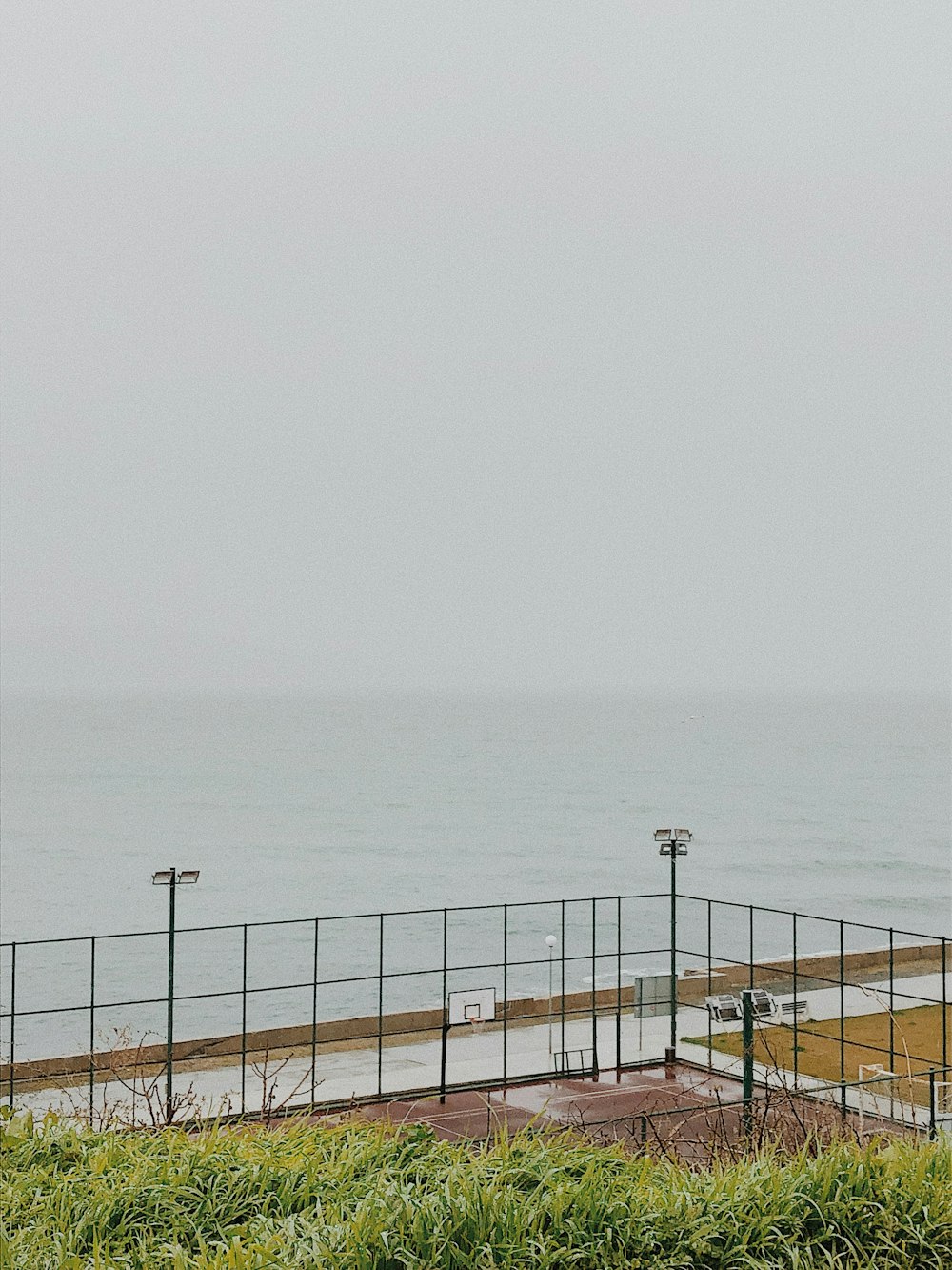 gray metal fence near sea during daytime