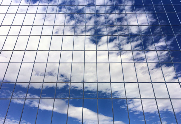 A close-up of sparkling clean windows reflecting a bright blue sky, showcasing Diamond Lustre's shine.