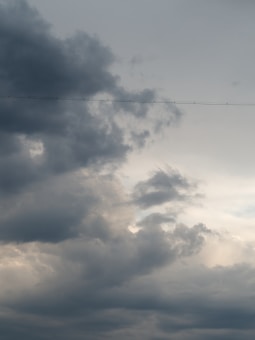Dark, heavy clouds fill the sky, indicating overcast weather. A thin horizontal wire stretches across the upper portion, intersecting the view.