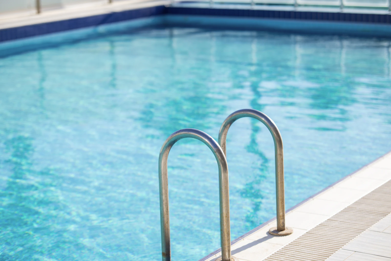 Clean blue swimming pool with stainless handrails
