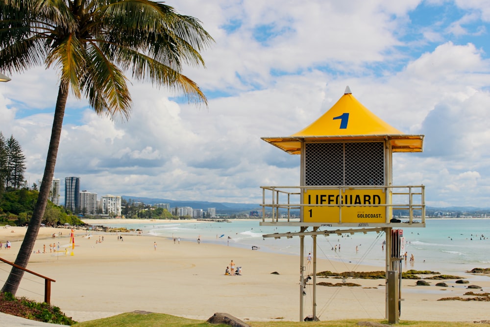 yellow and white lifeguard tower on beach during daytime