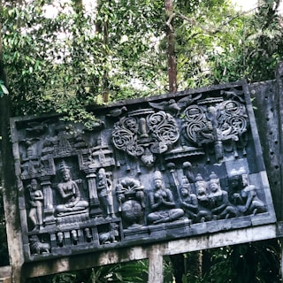 A detailed sculpture of Shiva meditating in a forest