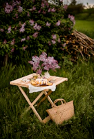 A rustic wooden table showcasing a cake decorated with fresh lilacs and soft purple icing.