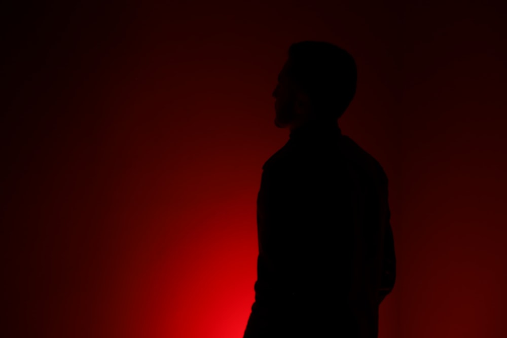 silhouette of person standing in front of red wall
