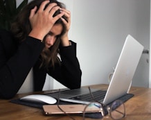 woman in black long sleeve shirt covering her face with her hands