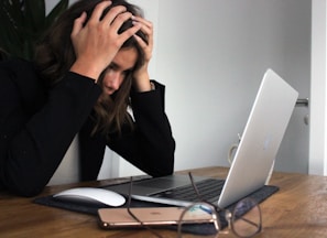 woman in black long sleeve shirt covering her face with her hands