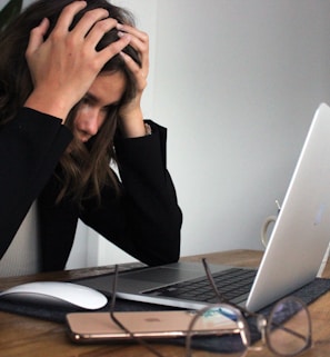 woman in black long sleeve shirt covering her face with her hands