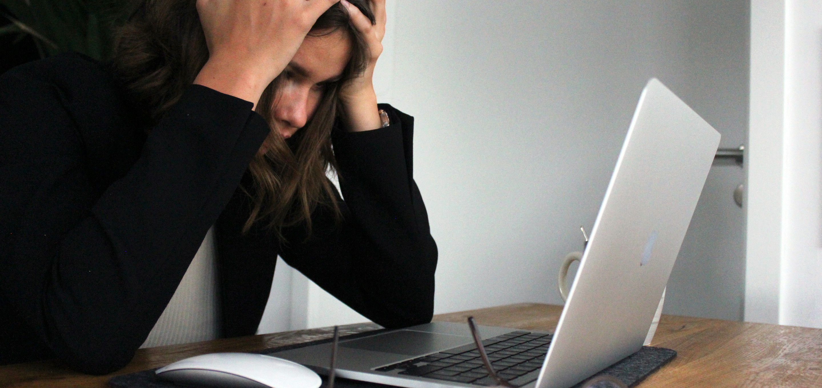 woman in black long sleeve shirt covering her face with her hands