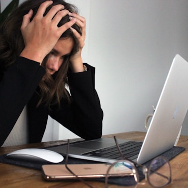 woman in black long sleeve shirt covering her face with her hands