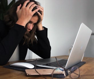 woman in black long sleeve shirt covering her face with her hands