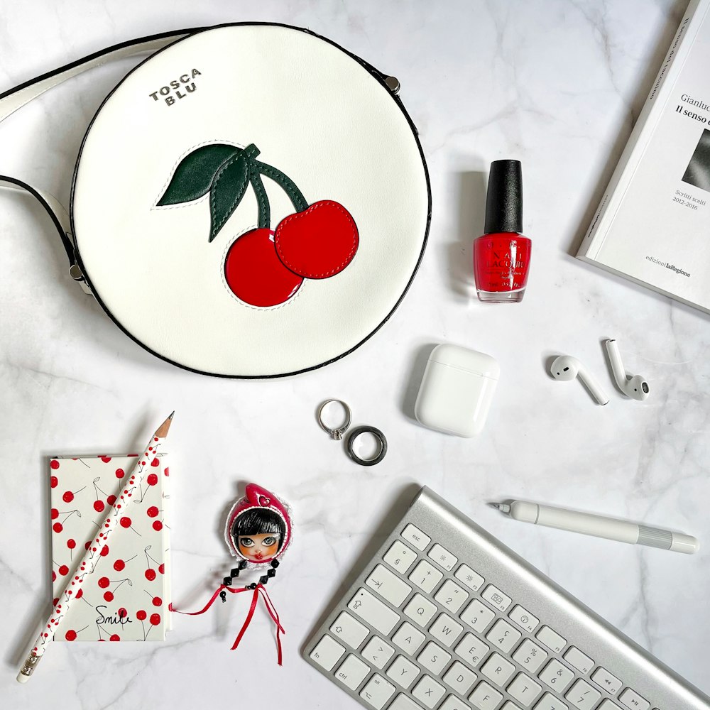 white and red floral round plate beside white computer keyboard and red and white click pen