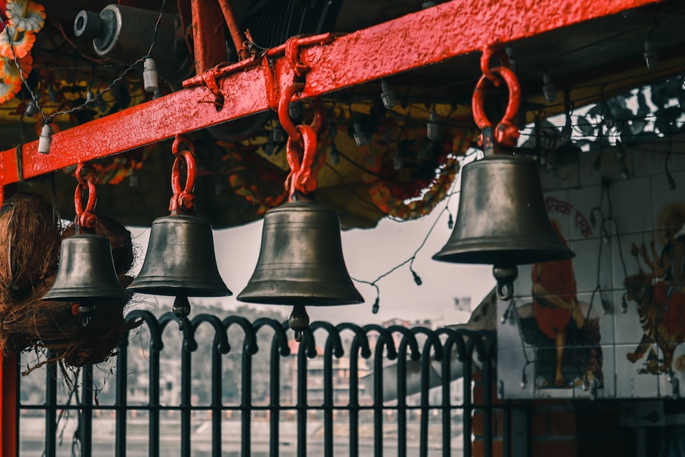 black and red bell hanging on red metal bar