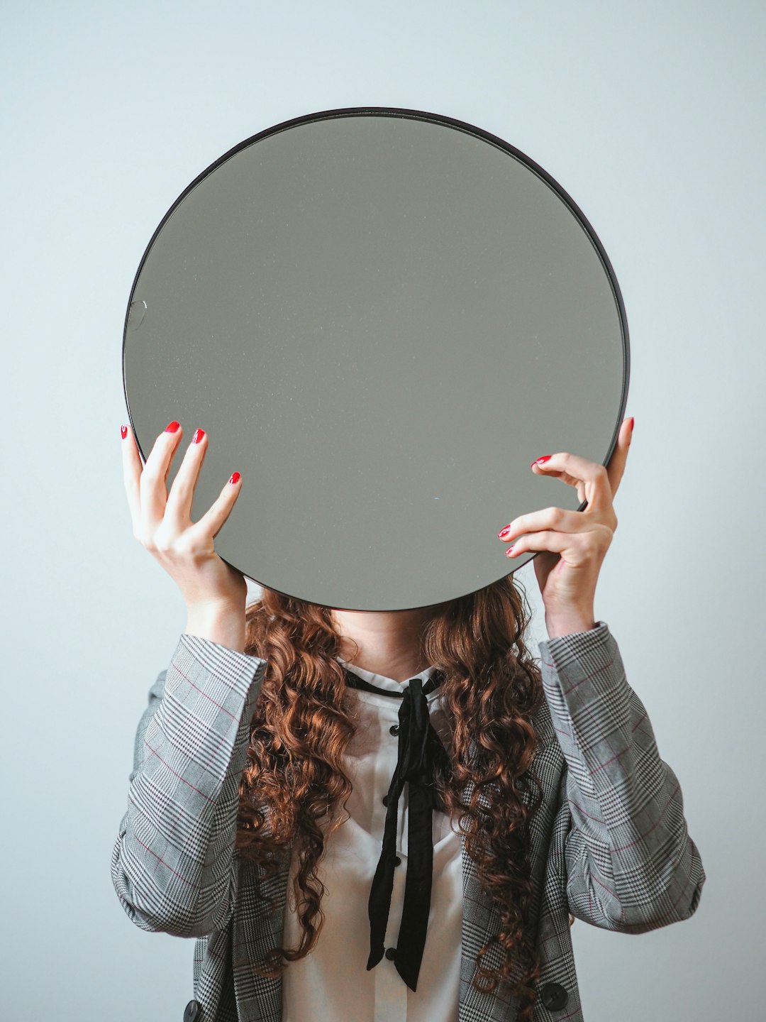 person holding round black mirror