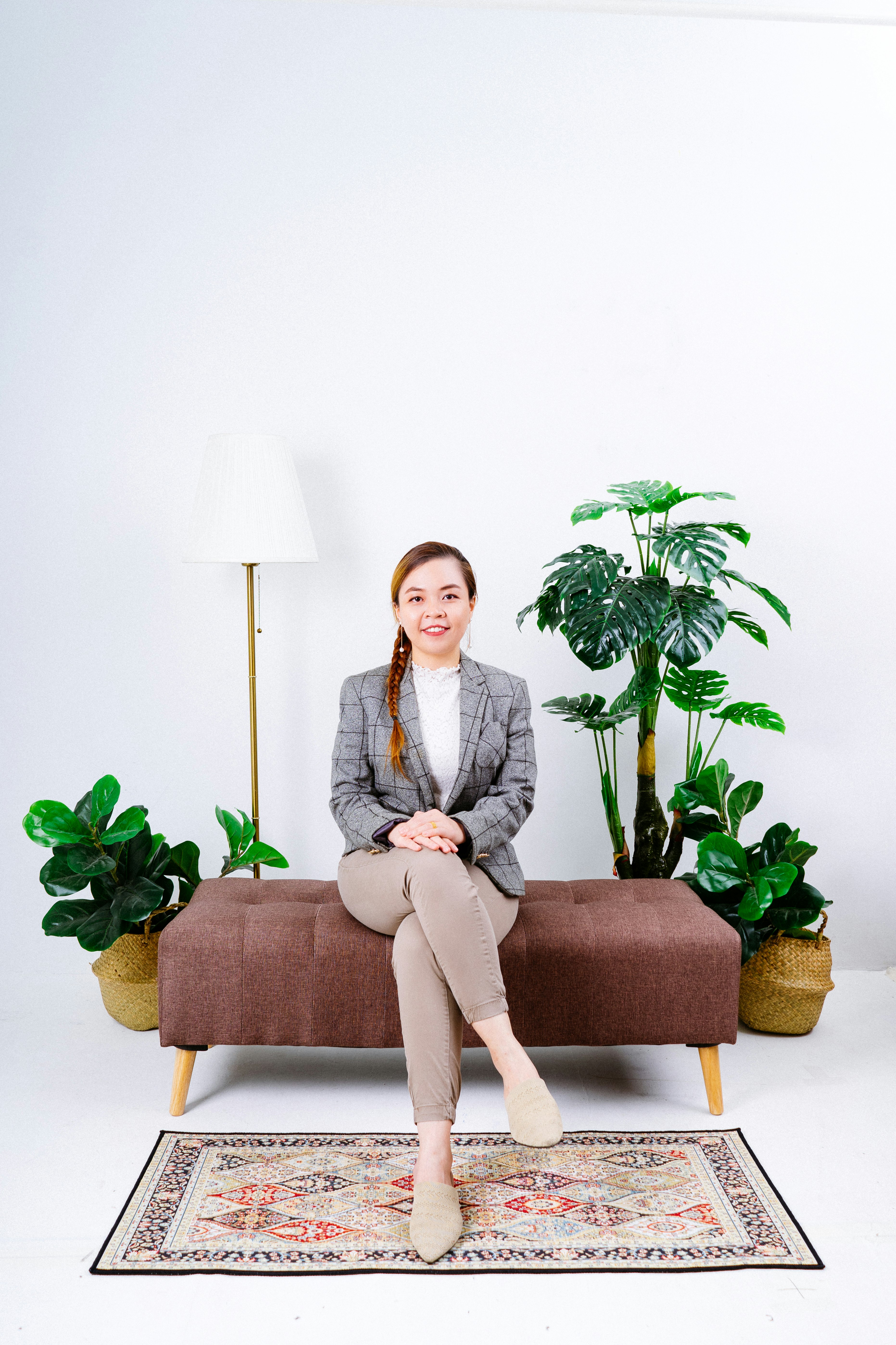 woman in gray blazer sitting on brown sofa chair