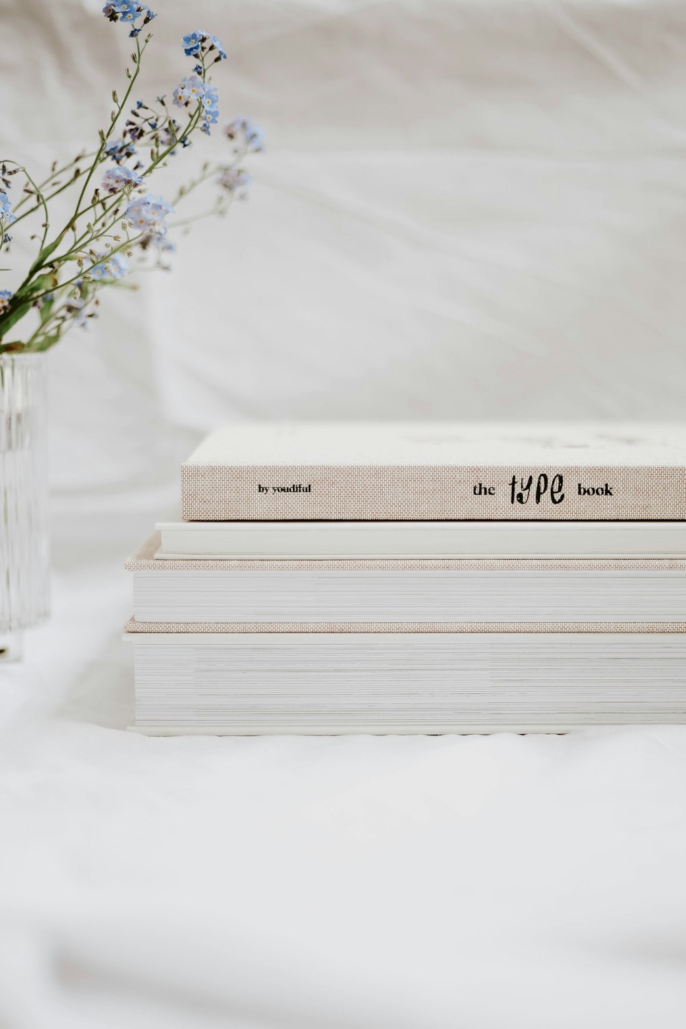 white and brown book on white textile