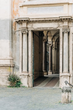 framing with frames for photo composition,how to photograph an ornate marble entrance to a condominium in rome, italy; green plant in front of white concrete building