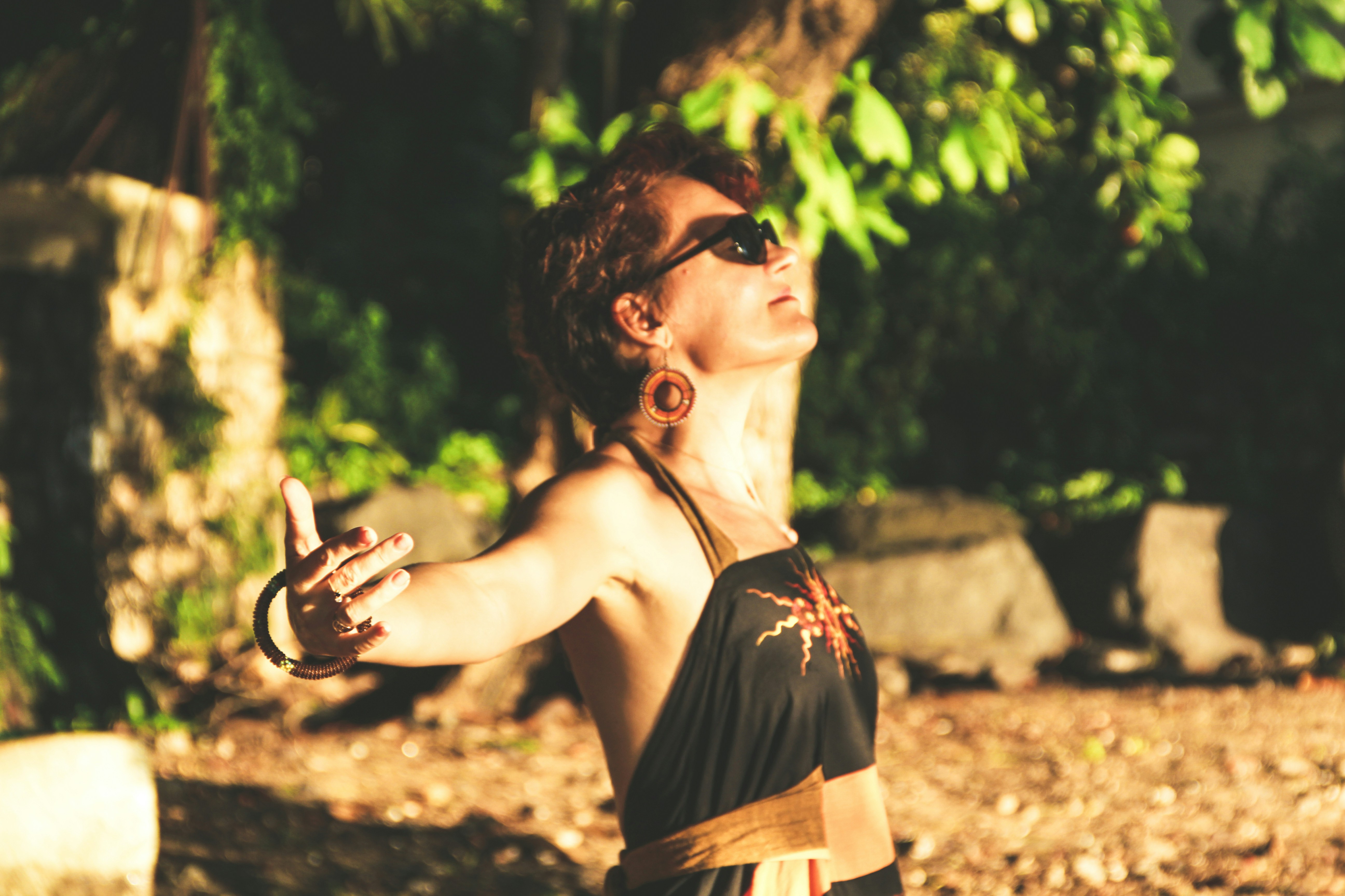 woman in black spaghetti strap top wearing black sunglasses