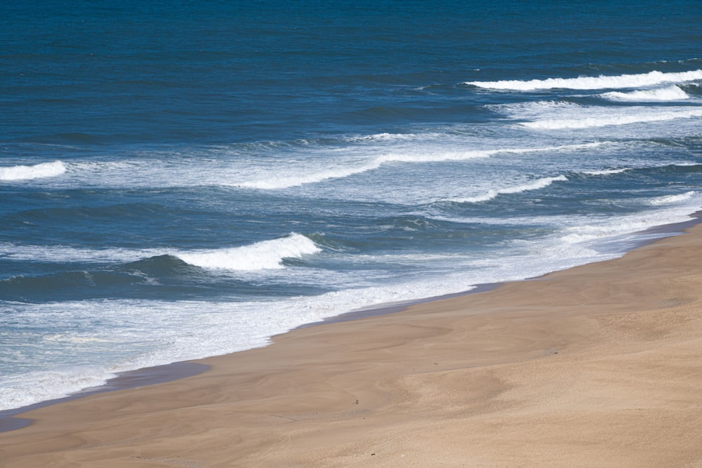 sea waves crashing on shore during daytime