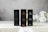 Three rectangular boxes labeled with different types of CBD oil are displayed on a flat surface. The boxes are labeled as Platinum, Bronze, and Silver, each with a different percentage of full-spectrum CBD oil. The background appears to be softly blurred, with white flowers adding a subtle decorative touch.