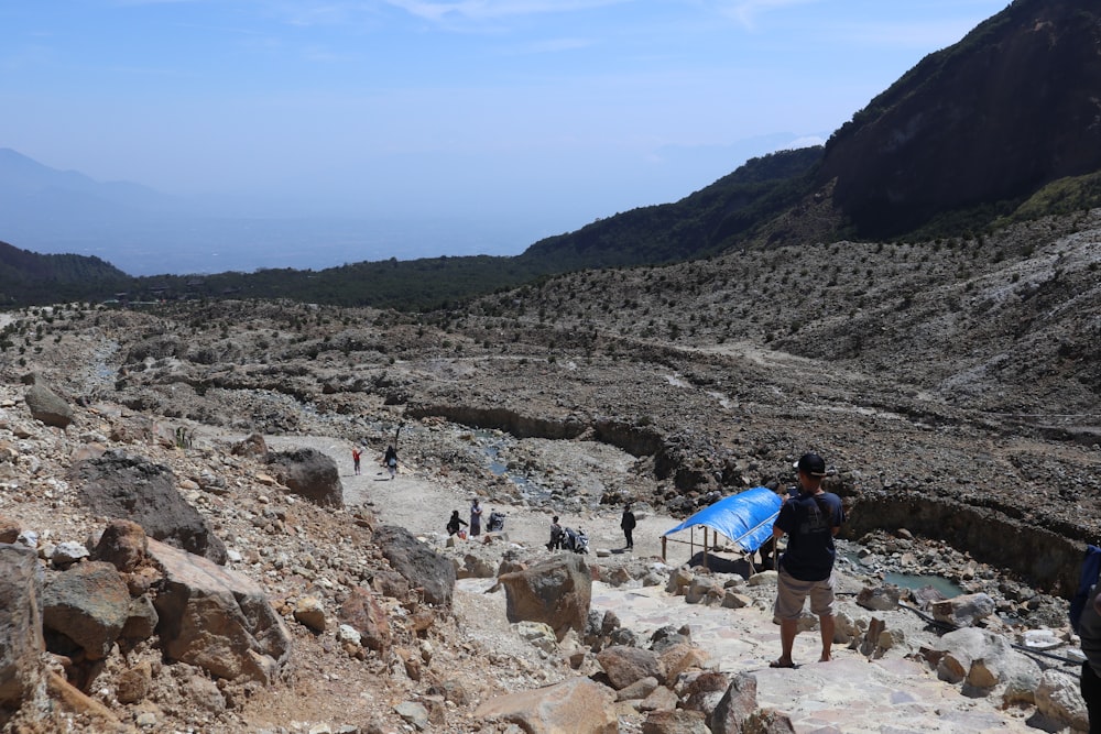 people walking on rocky hill during daytime