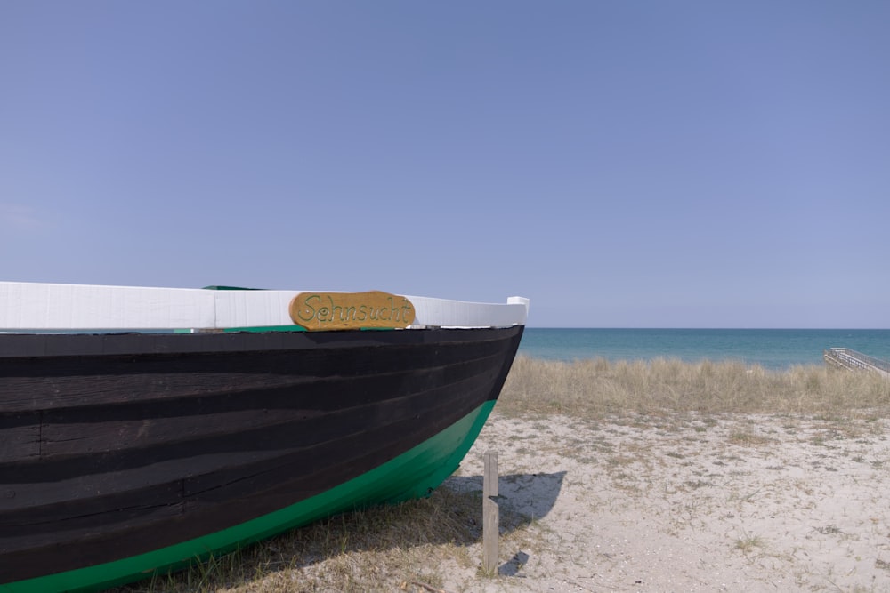 blau-weißes Boot am Strandufer tagsüber