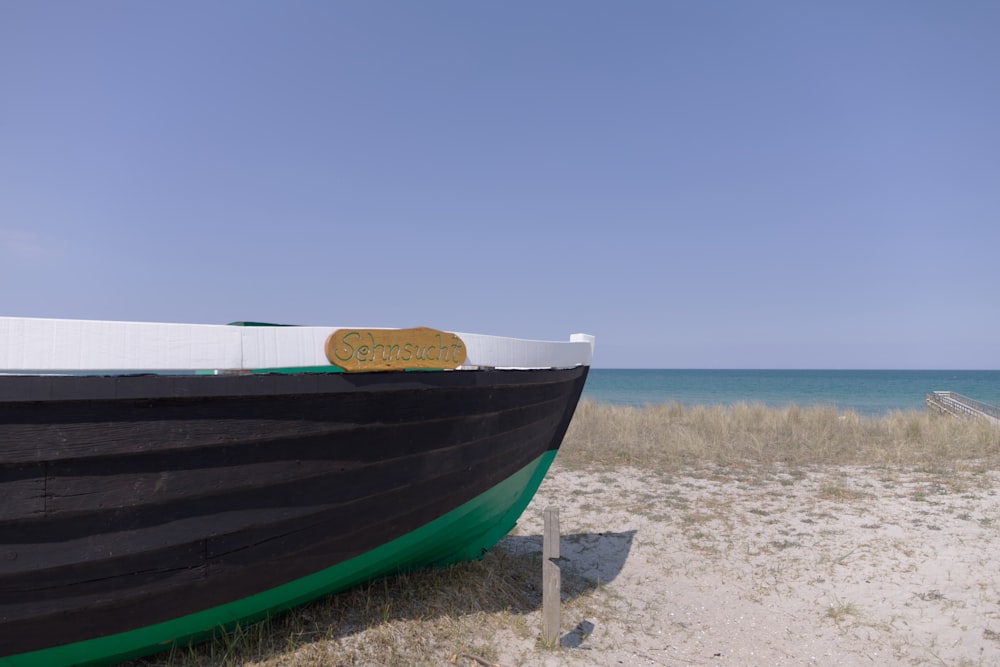 Barco azul y blanco en la orilla de la playa durante el día