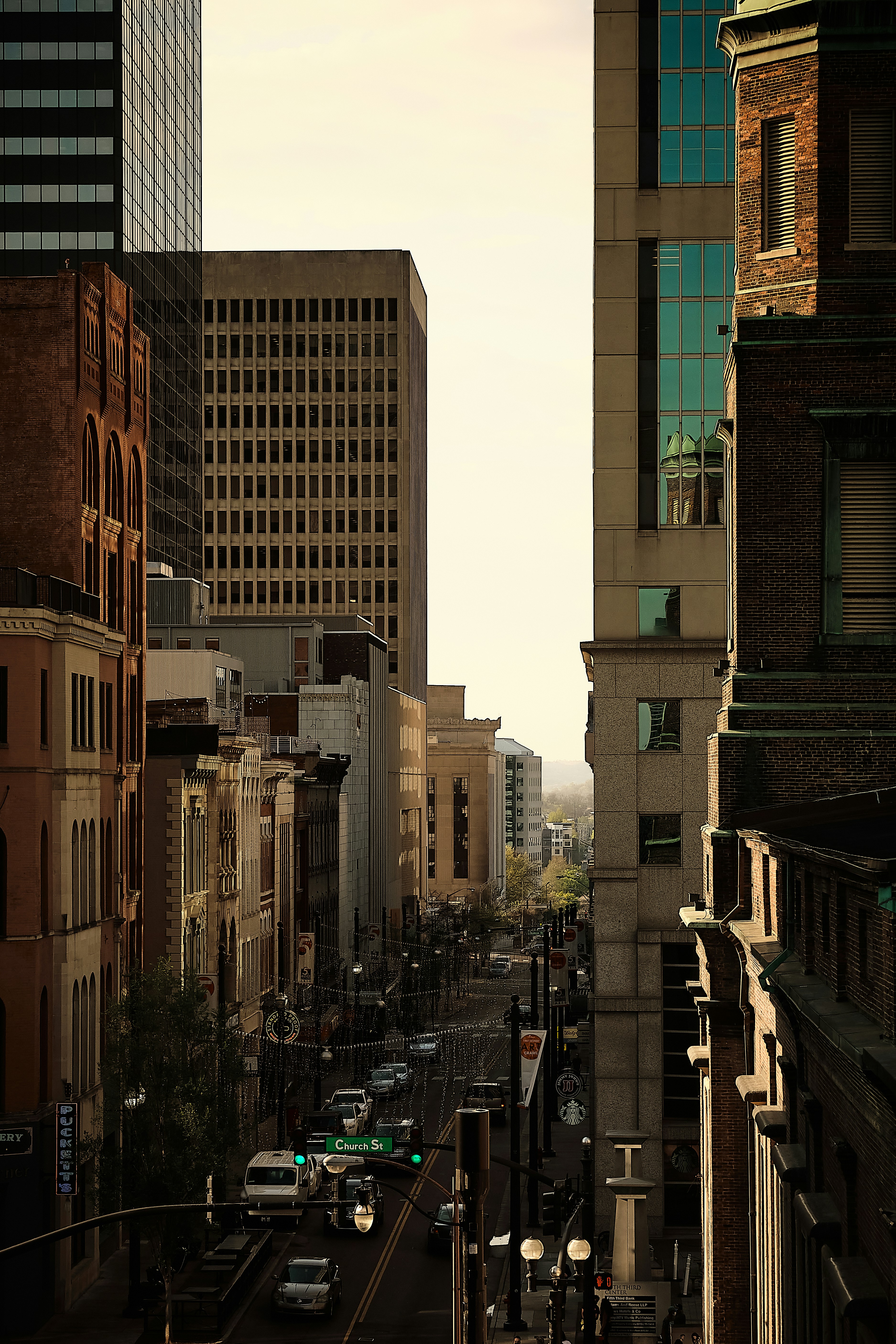 昼間、高層ビルの間の通りを歩く人々