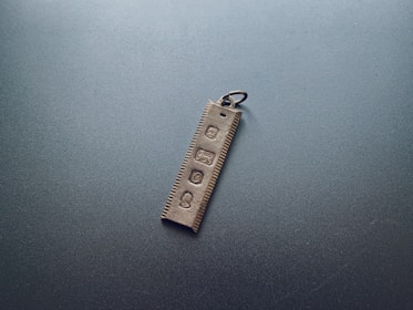 Hand holding a minimalist black NFC keychain with the init logo subtly embossed.