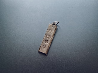 Hand holding a minimalist black NFC keychain with the init logo subtly embossed.