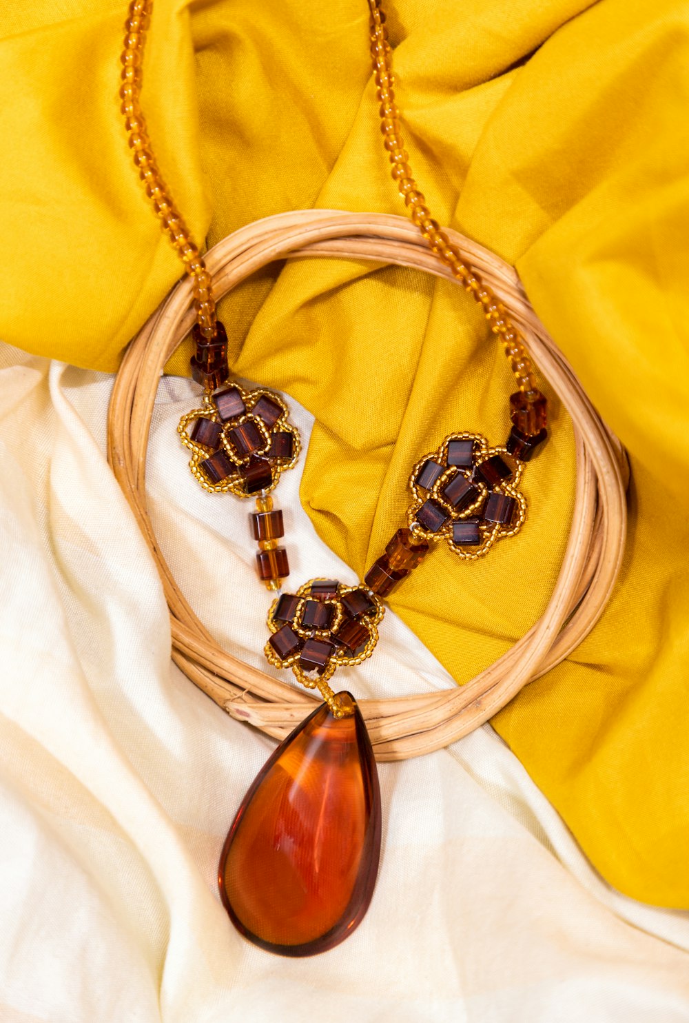 brown and white beaded necklace on white textile