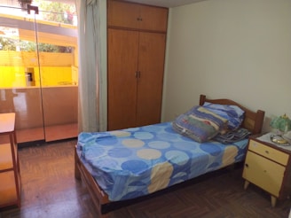 Compact single bed perfect for small spaces, styled with colorful pillows.