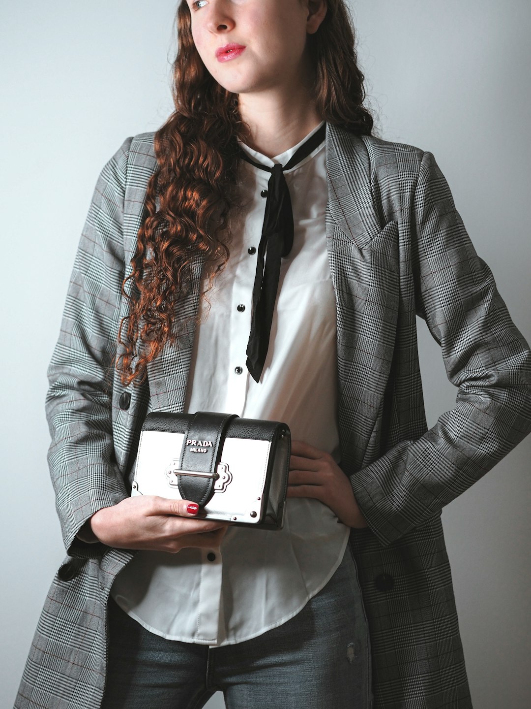 woman in gray blazer holding black and white camera