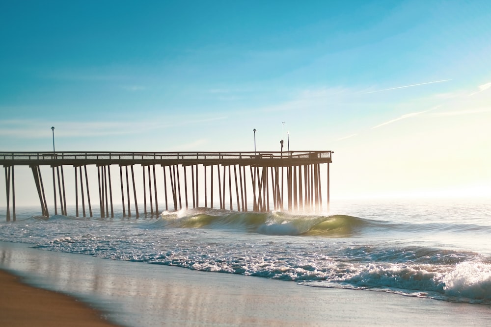 brown wooden dock on sea under blue sky during daytime