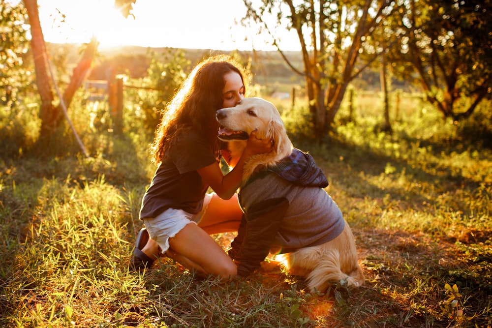 woman in brown t-shirt hugging white dog