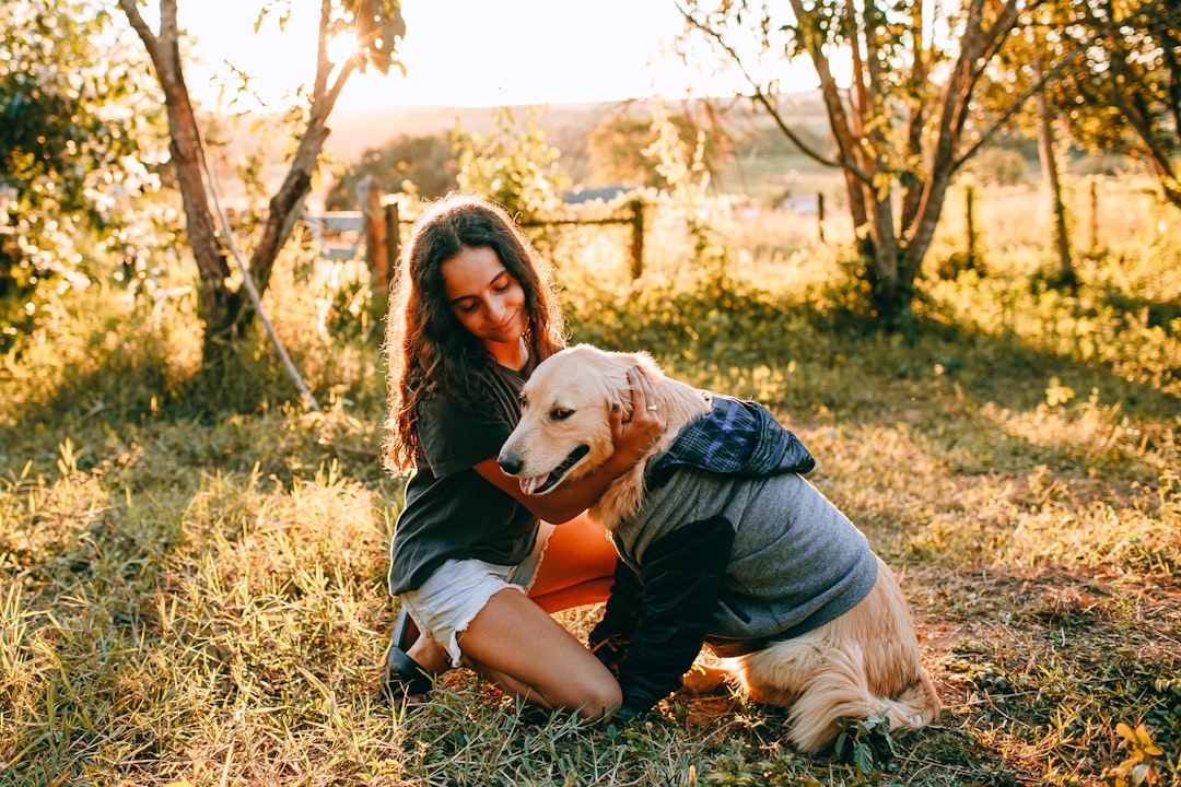 man in black t-shirt hugging brown dog