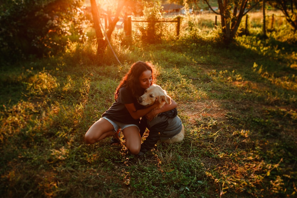 woman in brown shirt carrying white dog