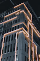 Modern building facade lit up at night showcasing electrical design.