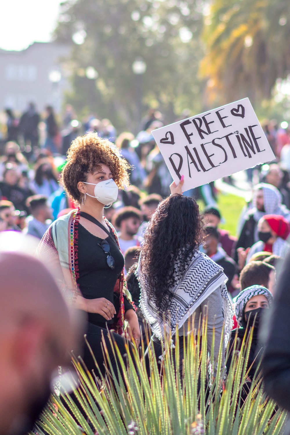 woman in black and white long sleeve shirt holding white and blue signage