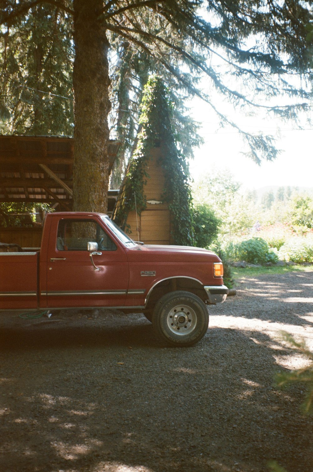 red crew cab pickup truck parked near green trees during daytime