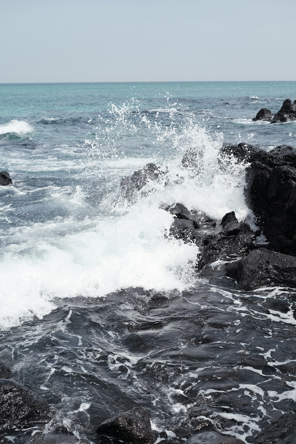 ocean waves crashing on rocks during daytime