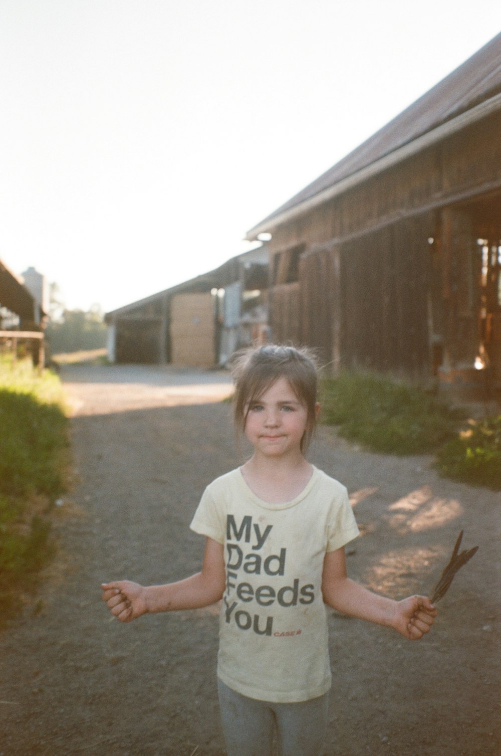 girl in white crew neck t-shirt standing on pathway during daytime