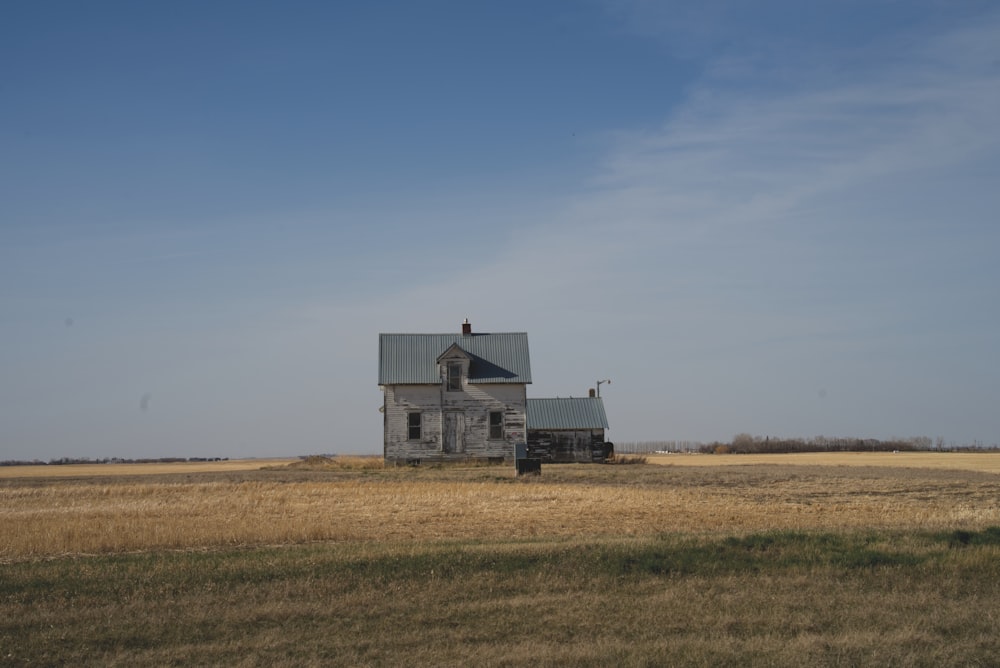 white and black house on green grass field under blue sky during daytime