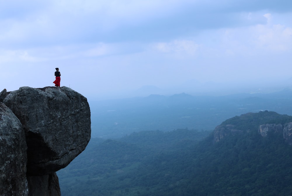 person standing on rock formation during daytime