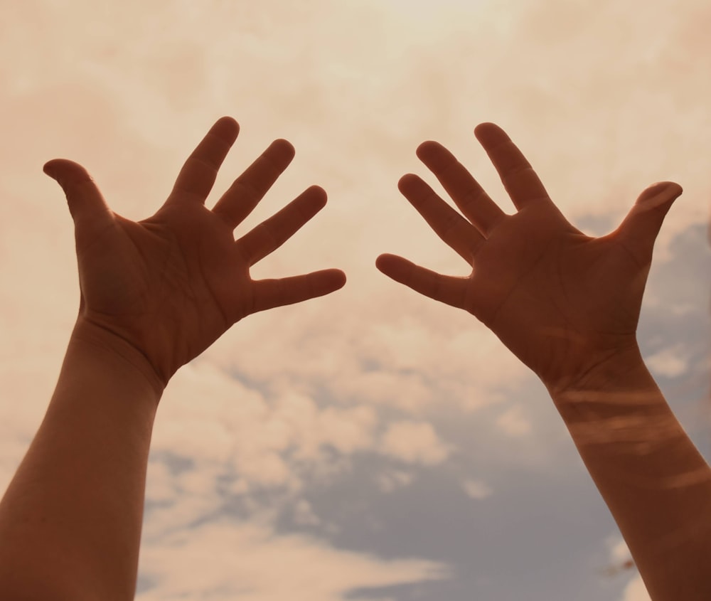 persone mano sinistra sotto cielo blu durante il giorno