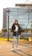 woman in gray coat and blue denim jeans sitting on bench during daytime