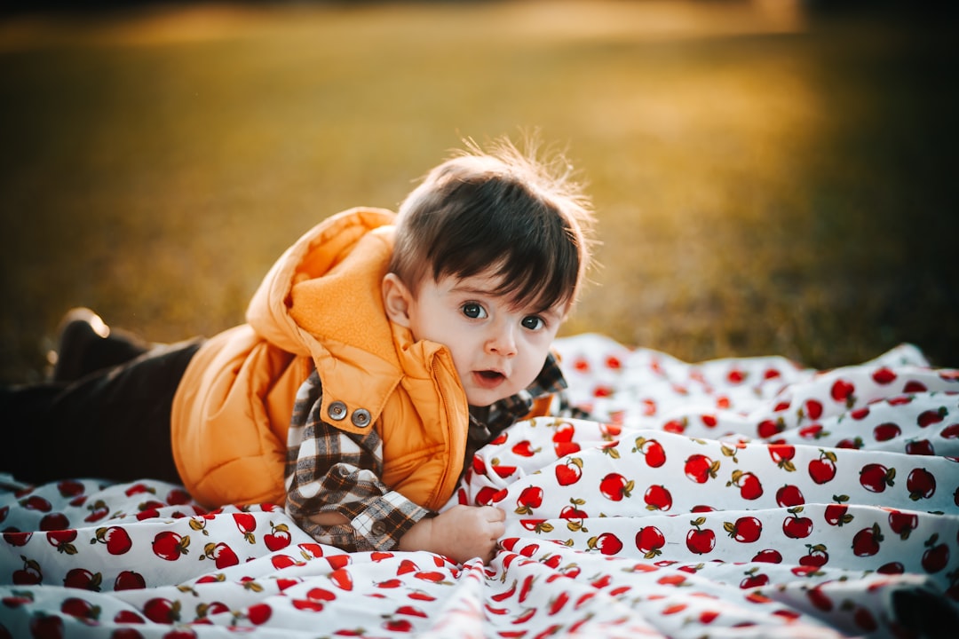 boy in orange hoodie lying on bed