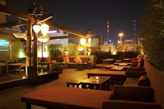 A cozy lounge terrace at sunset with warm lighting and comfortable seating.