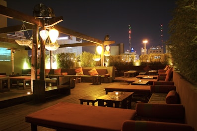 Rooftop banquet area set up for an evening event with twinkling lights and comfortable seating.