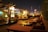 A cozy rooftop dining area with softly lit tables overlooking a city skyline at dusk.