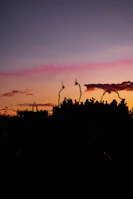 A group of friends dressed in vibrant Lumina Apparel pieces laughing on a rooftop at sunset.